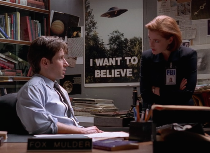 Os personagens Fox Mulder e Danna Scully da série e o cartaz "I Want to Believe" (Eu Quero Acreditar) da série Arquivo X (1993 - )